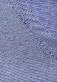 Helleblauer Strickstoff mit glatter Textur. Verfügbar mit einem gerippten Rand und einer diagonalen Naht, die enge Nähte und einen subtile Glanz präsentiert.