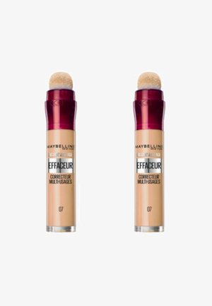 Deux tubes de correcteur Maybelline avec une base transparente et un grand applicateur en mousse arrondi. Les bouchons sont d'un rouge foncé et la teinte du produit est 07.