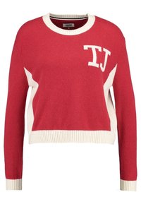 Czerwony i biały sweter z dzianiny z długimi rękawami, okrągłym dekoltem i białymi literami "TJ" na górnej lewej części klatki piersiowej.