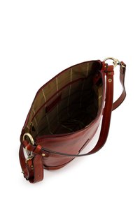Sac à main en cuir rouge avec fermeture éclair, bandoulière ajustable et intérieur en tissu à carreaux avec des poches pour l'organisation.
