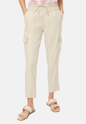 Beige, lichtgewicht cargobroek met een elastische tailleband, aantrekkoord en zijzakken. Gecombineerd met beige sandalen met een brede band.