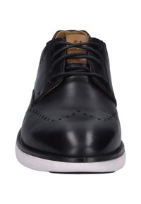 Czarne skórzane buty na średnim obcasie o gładkim wykończeniu, z sznurowanym zapięciem, z brązowymi akcentami na języku oraz ozdobnymi perforacjami na nosku.