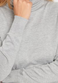Grauer Rollkragenpullover mit geripptem Ausschnitt und Bündchendetails, weicher, glatter Textur und lockerer Passform.