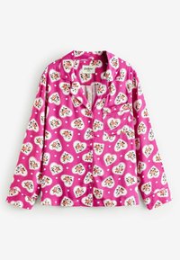 Top in pigiama rosa con motivi floreali a forma di cuore su sfondo a pois, maniche lunghe e colletto a punte con taschino sul petto.