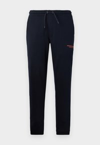 Navy drawstring joggers med sidelommer, tapered ben og orange "WEEKEND OFFICER" tekst på højre lår. Blødt bomuldsblandingsmateriale.
