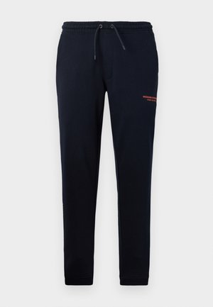 Navy drawstring joggers with side pockets, tapered legs, and orange "WEEKEND OFFICER" text on the right thigh. Soft cotton blend material.