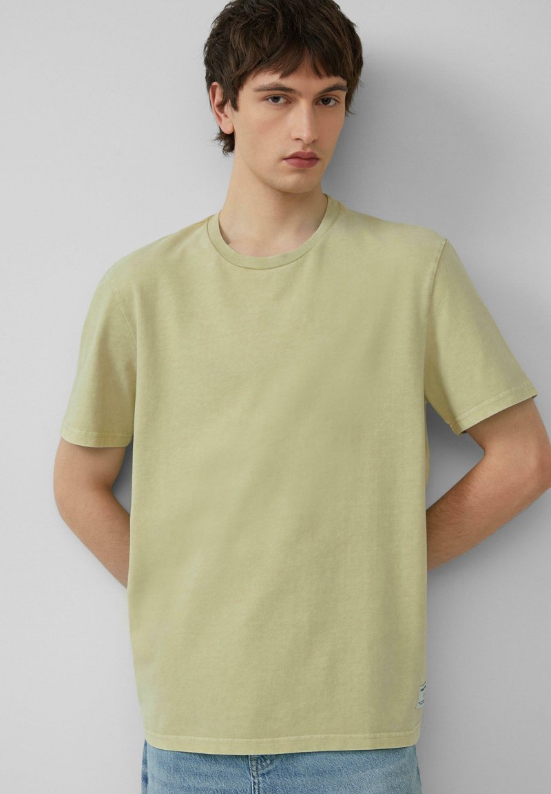 Hellgrünes Baumwoll-T-Shirt mit Rundhalsausschnitt, kurzen Ärmeln und geradem Schnitt. Verfügt über ein kleines Etikett am Saum.