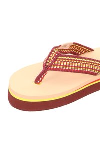 Flip-flop featuring a textured multicolored strap in shades of red and yellow, with a beige footbed and a layered brown and yellow sole.