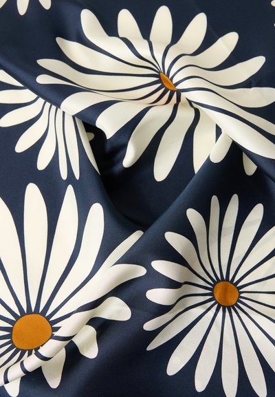Ύφασμα σε ναυτικό μπλε χρώμα με μεγάλα σχέδια λευκών μαργαριτών με πορτοκαλί κέντρα, απεικονιζόμενο με απαλά γυρίσματα και λεία υφή.