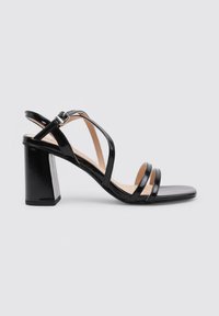 Sandalias de tacón de charol negro con cuatro tiras entrelazadas y un elegante tacón cuadrado. Las tiras cuentan con una hebilla para ajustes.