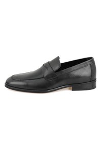 Schwarzer Lederloafer mit glatter Oberfläche, runder Form, gestickten Details und niedrigem Absatz. Rutschfeste Ausführung mit einem dekorativen Riemen über dem Vorderblatt.