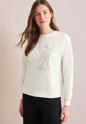 Felpa bianca con un logo texturizzato sul davanti, polsini a coste e scollatura rotonda, abbinata a pantaloni neri.