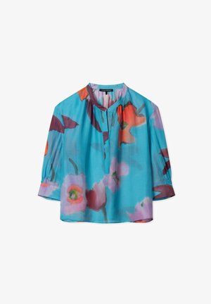 Light blue blouse featuring a floral pattern in red, orange, and purple, with a front keyhole opening and gathered sleeves. Smooth fabric.