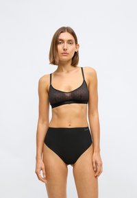 Sort lingeriset bestående af en gennemsigtig, mønstret bralette med justerbare stropper og højtaljede sorte trusser. Blød, glat tekstur.
