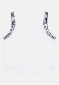 Biały top na ramiączkach z cienkimi paskami, z powtarzającym się logo Calvin Klein Jeans w czerni i szarości wzdłuż krawędzi ramiączek. Gładki materiał, prosty design.