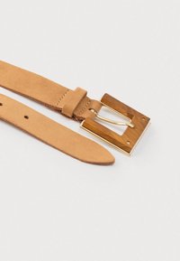 Tan-nahast vöö, millel on ruudukujuline puidust pandla ja kuldse metallist neetkinnitusega. Vöö on lame ja sile, disainilt lihtne.