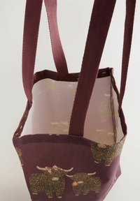 Square tote bag with purple fabric featuring a pattern of illustrated highland cows. Natural fiber handles and a mesh lining.
