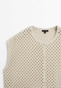 Cremfarbener Strickwesten mit offenem Häkelmuster, ausgestattet mit einem runden Ausschnitt und einer durchgehenden Knopfleiste.