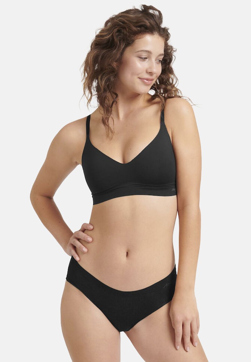 Schwarzes Bralette mit dünnen verstellbaren Trägern, einem tiefen Ausschnitt und einem glatten elastischen Band, kombiniert mit passendem niedrig sitzendem Unterwäsche.
