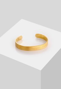 Bracciale in oro con finitura spazzolata, caratterizzato da una forma liscia e arrotondata con estremità aperte, adatto per una vestibilità regolabile.