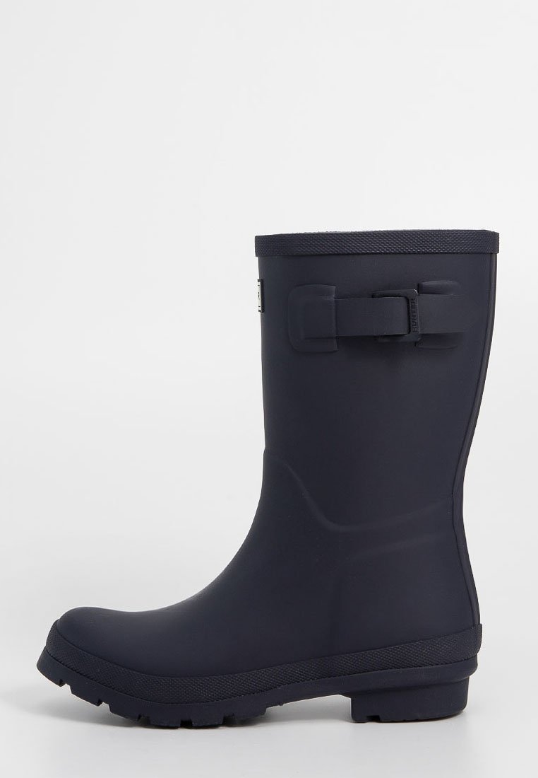 Bota de lluvia de goma en color navy con suela texturizada, abertura amplia y detalle de hebilla ajustable en el costado. Acabado liso en toda la bota.