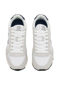 Zapatillas blancas y grises con parte superior de malla y gamuza, cordones y una suela de goma negra. El texto en la lengüeta dice "CORRE MÁS RÁPIDO DE LO QUE PUEDES."