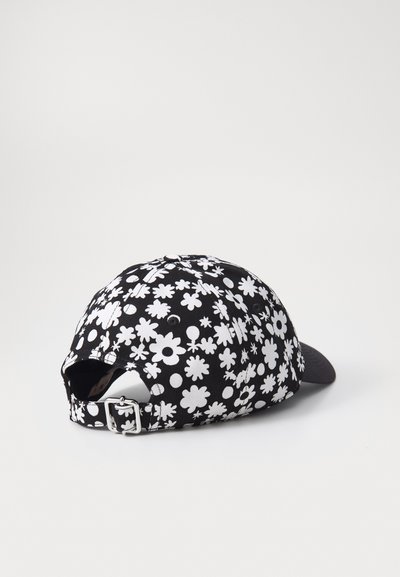 Gorra negra con un patrón floral blanco de diversas formas de flores. Correa ajustable en la parte trasera, visera plana y tejido texturizado.