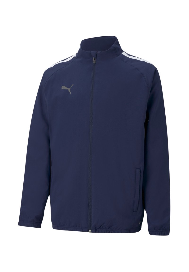 Marineblauwe sportjack met een opstaand kraag, ritsluiting, zijzakken, witte strepen op de schouders en een reflecterend logo op de borst.