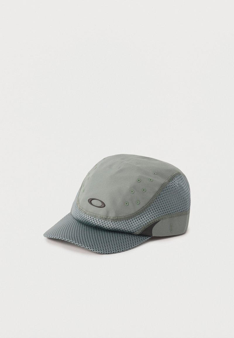 Lichtgrijze Oakley-pet met meshpanelen, ventilatiegaten en een gebogen klep, weergegeven op een effen witte achtergrond.