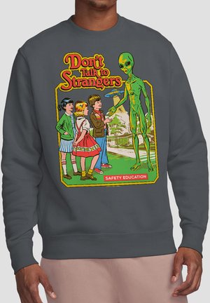 Three children stand cautiously as a green alien reaches out, with text "Don't Talk to Strangers" and "Safety Education" on a sweatshirt.