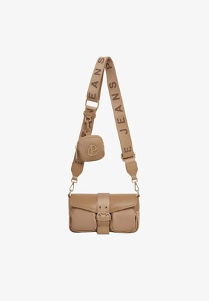 Beżowa prostokątna torba typu crossbody z zapięciem na klamrę, dwie przednie kieszenie, gruby regulowany pasek z napisem "JEANS" oraz mała przytwierdzona saszetka.