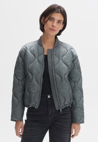 Gelaagde bomberjack in donkergrijs, met ritsluiting, ribbelhals en elastische onderkant. Glad, glanzend materiaal met een puffy textuur.