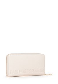 Portafoglio in pelle color crema, forma rettangolare, con testo in rilievo "I AM RESPONSIBLE", con una cerniera dorata e finitura strutturata.