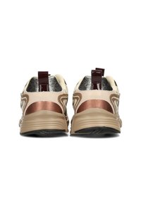 Des baskets avec une palette de couleurs crème et bronze, des accents métalliques, un soutien arrière texturé et une semelle beige flexible.