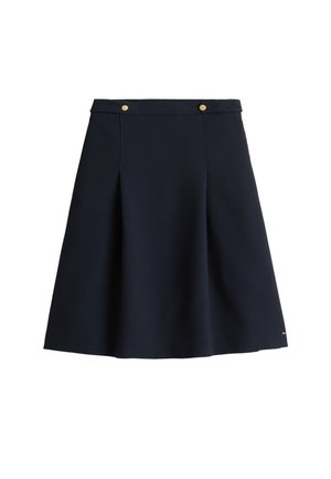 Jupe trapèze bleu marine taille haute, avec deux boutons dorés à la ceinture et des plis subtils sur le devant.