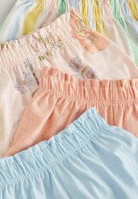 Drei Paar Shorts mit elastischem Bund in Pastellfarben: pink mit floralem Muster, hellblau und gestreift mit grünen, gelben und orangen Akzenten.