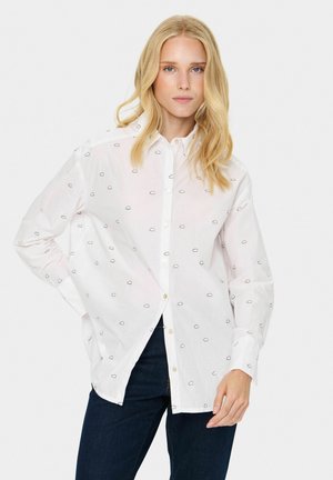 Witte button-up shirt met zwarte geborduurde wolkenvormen, met lange mouwen en een relaxte fit. Combineer met donkere denim jeans.