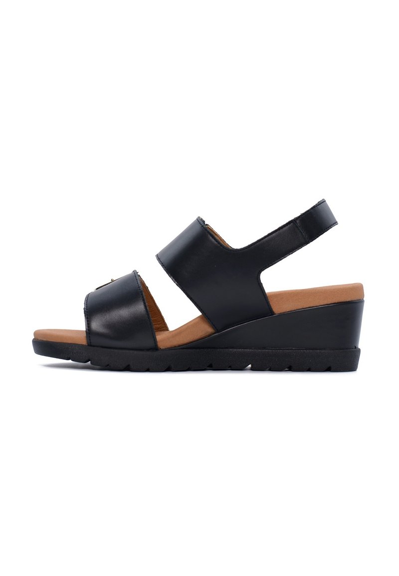 Le sandali con tacco a cuneo neri presentano ampie fasce in pelle liscia, una soletta color tan e una suola in gomma testurizzata per una migliore aderenza.