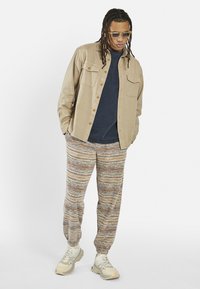 Redefined Rebel DANE PANTS COMFORT FIT - Pantaloni sportivi - inca gold