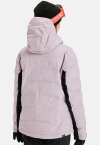 Light purple puffer jacket with black side panels, quilted texture, adjustable hood, and thumbhole cuffs, designed for winter sports.