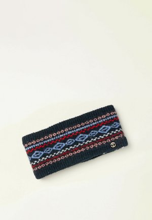 Diadema negra tejida con patrones geométricos en rojo, azul, rosa y blanco, y una pequeña chapa redonda de logo plateado sobre un fondo blanco.