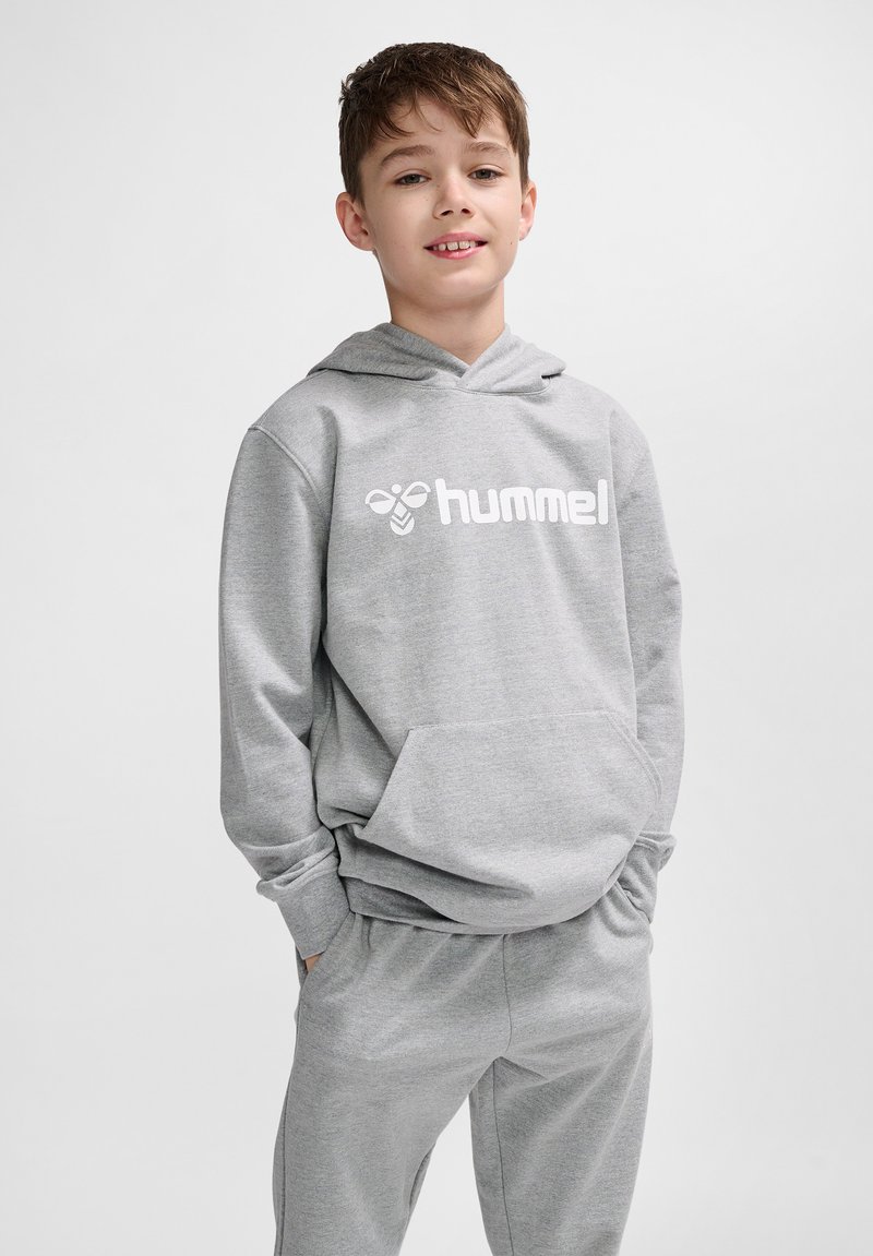 Grau Hoodie aus weichem Material, mit einer Vorderstasche und einem weißen Logo. Kombiniert mit passenden grauen Jogginghosen. Lässige Passform und Design.