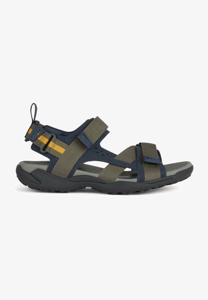 Sport sandals with navy and olive green straps, adjustable buckles, textured footbed, and flexible black sole. Features multi-directional tread.