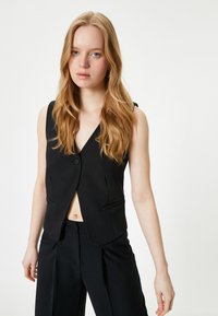 Schwarze ärmellose Weste mit V-Ausschnitt, einem Knopfverschluss und zwei vorderen Taschen; leichter Stoff mit glatter Textur.