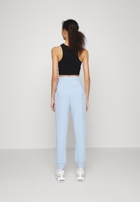 NA-KD PAMELA REIF x NA-KD - TRACKSUIT BOTTOMS - Calças de fato de treino - dusty blue