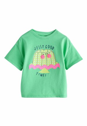 Zielona koszulka z krótkim rękawem z ilustracją żółtego galaretowatego deseru w kratkę, różowymi oczami z pomponów, różową falbanką oraz napisem "Galaretka na dobre czasy!"