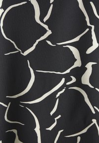 Tessuto nero con un motivo astratto bianco fluido, caratterizzato da curve e linee morbide, creando un aspetto texturizzato.