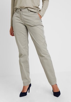 Beige katoenen broek met rechte pijpen, voorzien van riemlussen, zijzakken en een gladde textuur. Gecombineerd met marineblauwe hoge hakken.