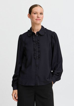Schwarze, knöpfbare Bluse mit einem Rüschenausschnitt und einer vorderen Blende; lange Ärmel mit gerafften Schultern; leichtes, glattes Material.