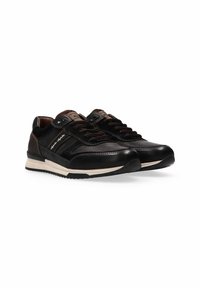 Scarpe sportive nere con tomaia in pelle, pannelli testurizzati, punta arrotondata e suola color crema. Presentano accenti e lacci marroni.